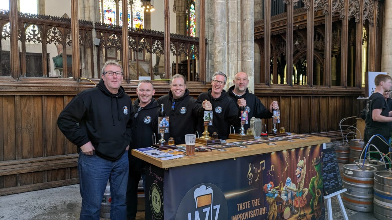 Five of the Jazz BrewCo founders behind their festival bar at Hull Minster, pump clips on show